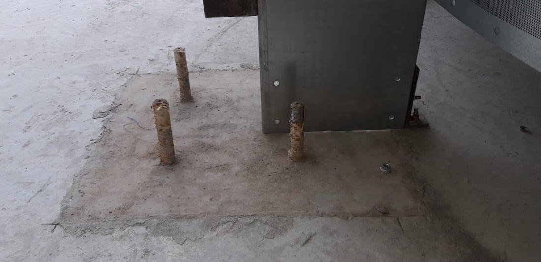 Cast-in anchor bolts in the concrete raft, their threads coated with cement laitance